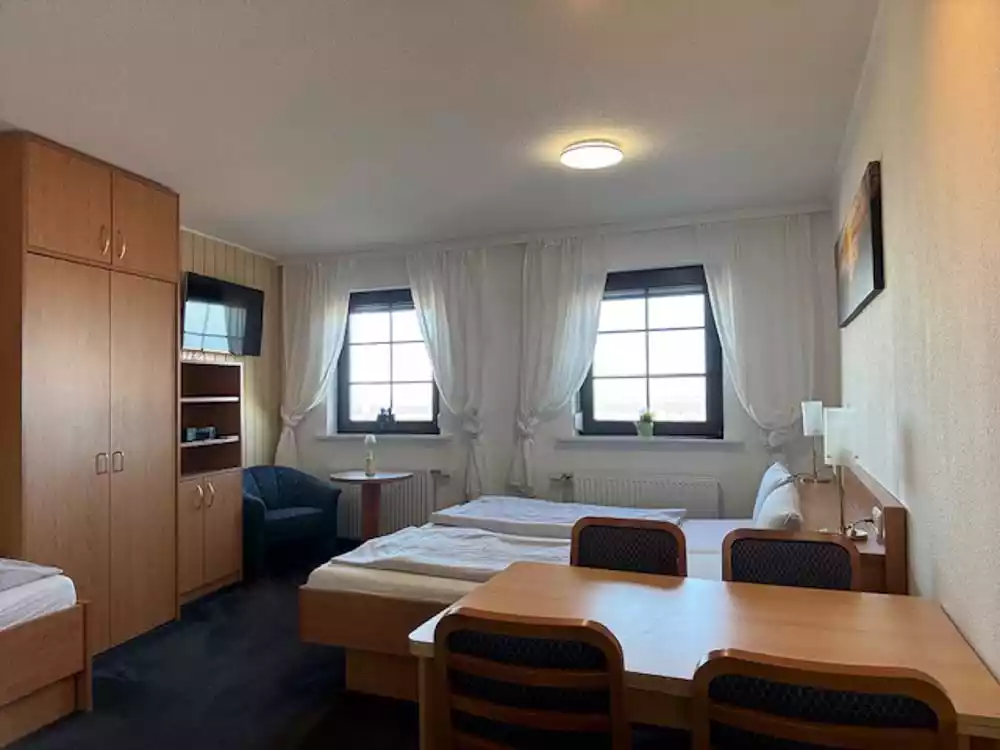 1-Raum Appartement mit einem Doppelbett, Einzelbett, Schrank, Tisch und Fernseher