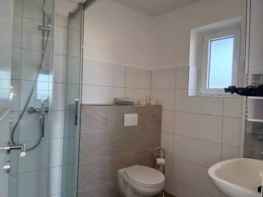 Badezimmer mit Dusche, WC und Waschbecken im 1-Raum Appartement